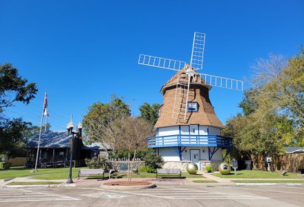 white windmill with blue trim on a clear day