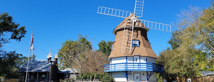 white windmill with blue trim on a clear day